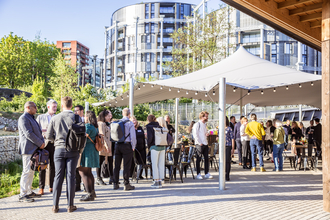 A group of people stand underneath a gazebo at Camley Street Natural Park