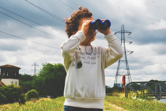 A child looking through binoculars at a nature reserve