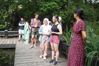 Young people standing around pond at Camley Street Natural Park 