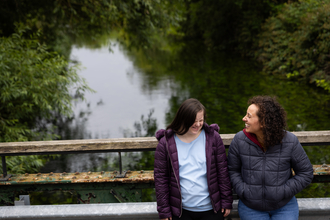 Two people laughing on bridge at Walthamstow Wetlands