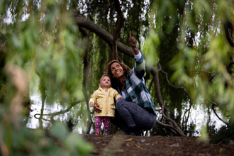 Woman and child underneath weeping willow tree