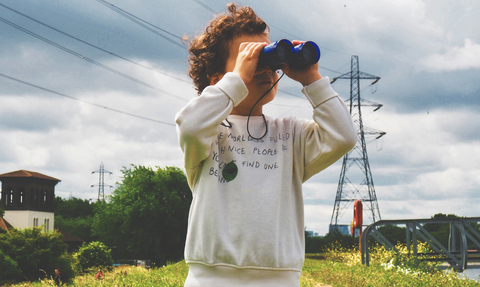 A child looking through binoculars at a nature reserve