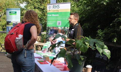 A young woman talking to a green charity representative at a stall at the Green Careers Showcase.