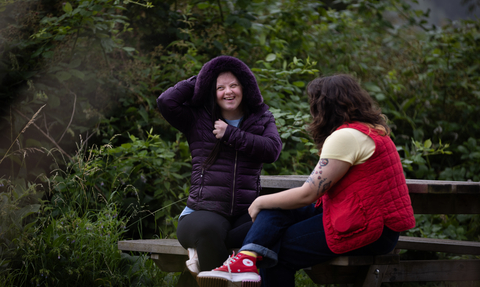 Two people sat at picnic bench in Walthamstow Wetlands