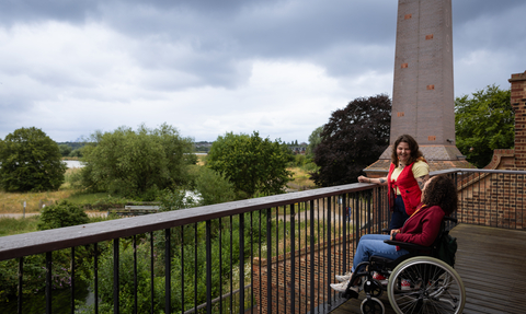 Two people laughing on the terrace at Walthamstow Wetlands