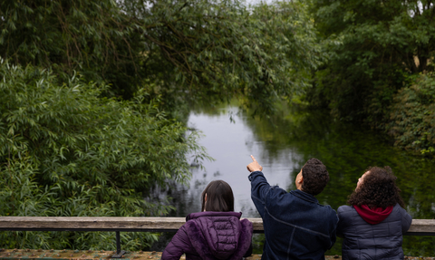 Three people looking over bridge at Walthamstow Wetlands