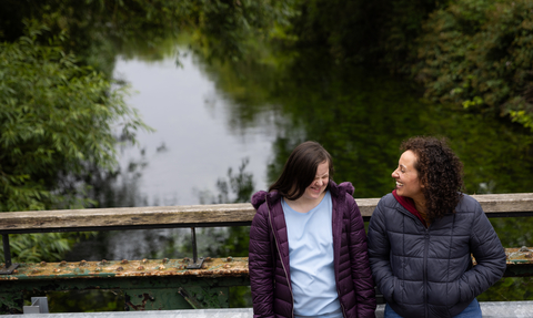 Two people laughing on bridge at Walthamstow Wetlands