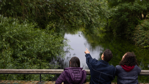 Three people looking over bridge at Walthamstow Wetlands