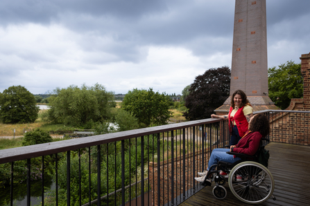 Two people laughing on the terrace at Walthamstow Wetlands