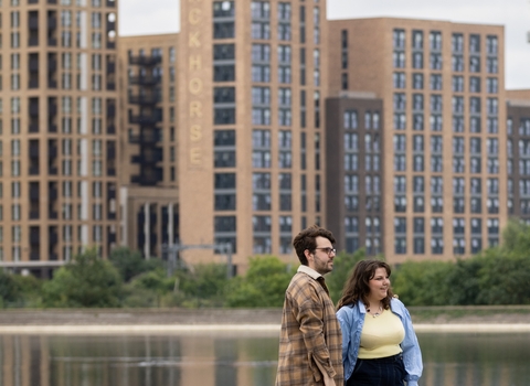 Two people stood on a concrete ledge overlooking water